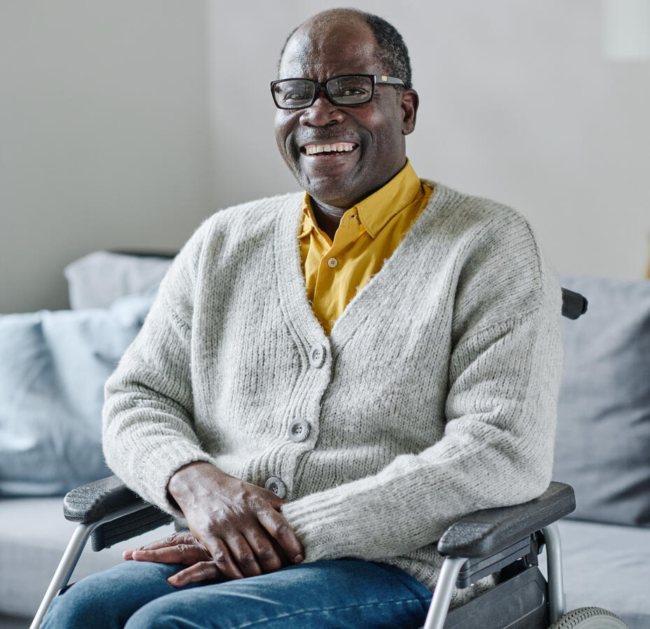 An elderly black man in a wheelchair, smiling.